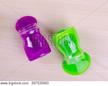 Bright Multi Colored Slimes On A Table. Kids Most Popular Toy Of Nowadays. Slime In Plastic Containe