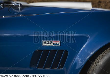 Placerville, USA - November 25, 2020: Classic rare American muscle car, convertible vintage blue 1967 Ford Shelby Cobra 427, close up of the logo