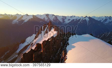 Epic Red Dawn On Top Of Snowy Mountains. Top View From A Drone. Huge Rocks Covered With Snow, The Le