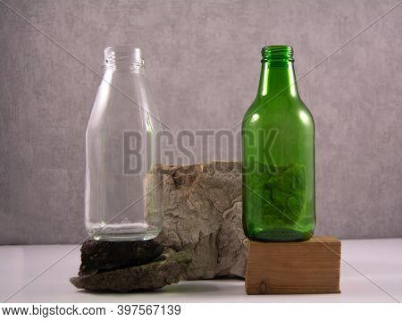 Recycling Concept. The Idea Of Preserving The Environment And Recycling Glass. Transparent Bottle An