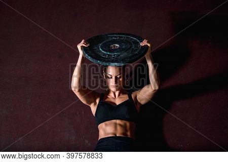 Young Strong Sweaty Fit Muscular Girl With Big Muscles Doing Sit Ups With Barbell Weight Plate For A