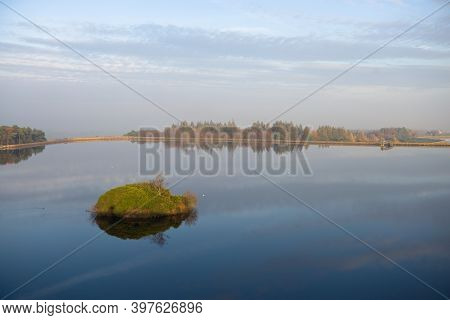 Small White Birds Rest On The Still Waters Surface At Redmires Reservoirs. Dam Wall Circles The Wate