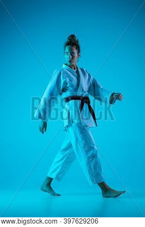 Walking. Professional Female Judoist In White Judo Kimono Practicing And Training Isolated On Blue N