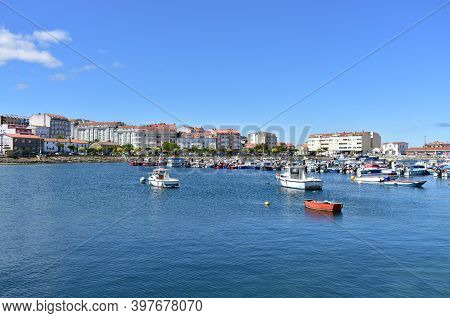 Portosin, Spain. Jun 30, 2020. Harbour And Coastal Village With Galician Fishing Vessels, Rowboats A