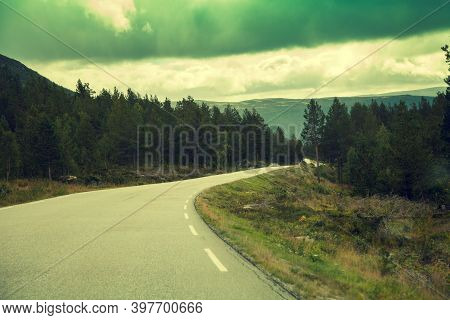 Mountain Road At Sunset With Dramatic Cloudy Sky