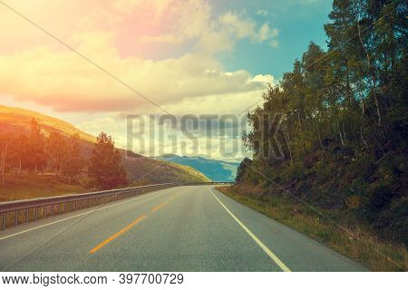 Mountain Road At Sunset With Cloudy Sky