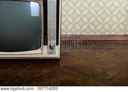 Retro tv set in room with vintage wallper and parquet, detail