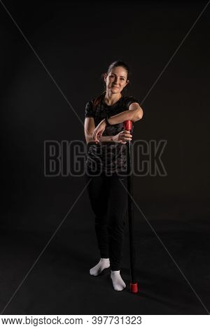Fitness Rests On A Bodybar Stands In A Rack. Is Engaged In Sports On A Black Background Beautiful Lo