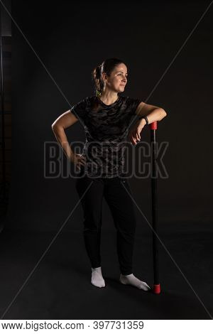 Fitness Girl Leans On The Bodybar Stretches Her Arms. Go In For Sports On A Black Background Beautif