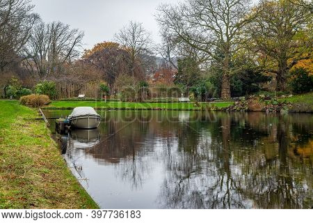 View Over The Canal To The Botanical Garden In Leiden, Netherlands With The Boat In Foreground