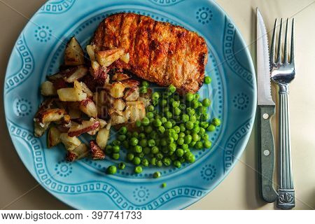 Grilled Porkchops Marinated In Honey Glaze With Baked Home Fries And Green Peas