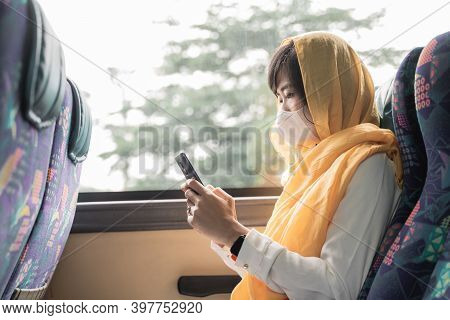 Muslim Woman With Face Mask Using Her Mobile Phone