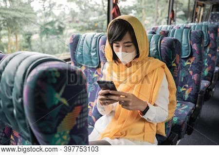 Muslim Woman With Face Mask Using Her Mobile Phone