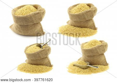 bulgur (couscous) in a burlap bag with an aluminum scoop on a white background