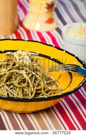 pasta pesto cotto e servito con un piatto tondo giallo
