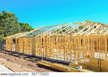 New Australian House Timber Frame Installation Process At Construction Site On A Bright Summer Day
