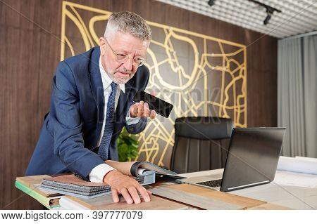 Businessman Speaking On Speakerphone When Choosing Wooden Sufrace For New Office Table