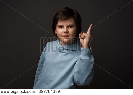 Portrait Of Serious Boy 10-12 Years Old In Casual Clothes Showing Index Finger, Scolding Or Telling 