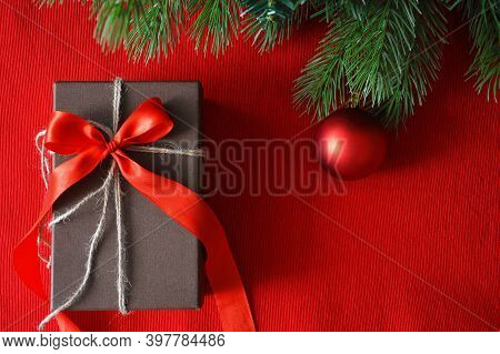 Spruce Green Branches On A Red Background And Red Ball, Christmas Toy. Happy New Year And Merry Chri