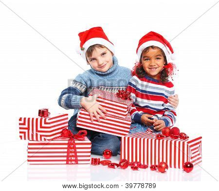 Niños pequeños en el sombrero de Santa Claus con caja de regalo