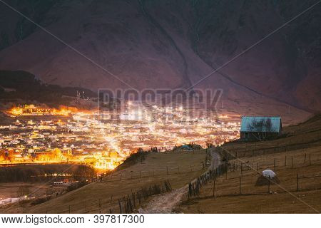 Stepantsminda, Georgia. Countryside Landscape At Evening Night Time On Mountain Background In Kazbeg