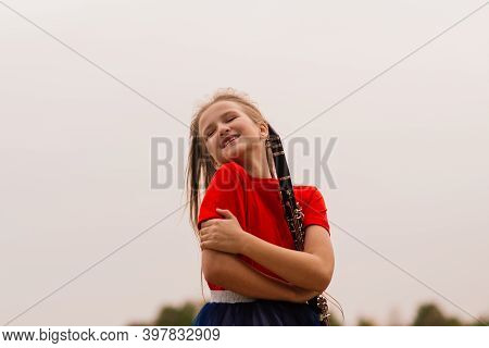Young Attractive Girl Playing Clarinet, Ebony In Fall Park