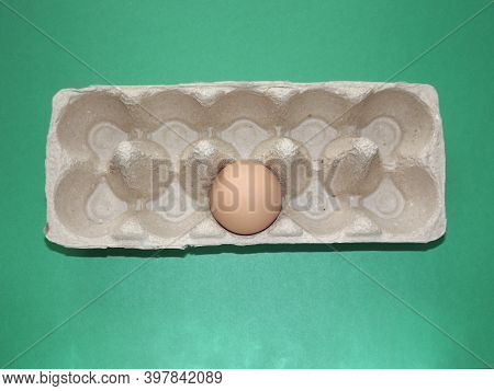 Beige Boiled Eggs In A Pot Of Water With An Egg Box On A Gray Background. High Quality Photo