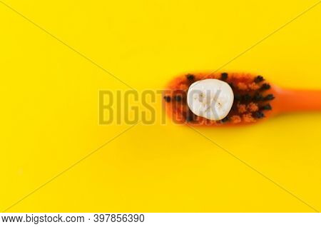Tooth brush and deciduous milk child teeth on yellow background