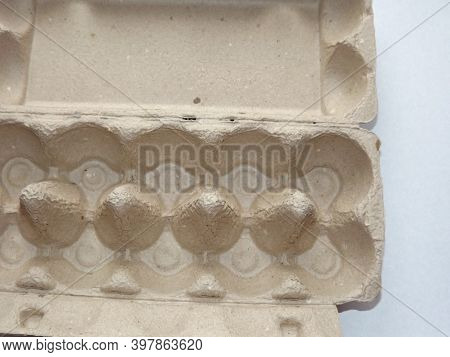 Beige Egg Box Empty On Purple Background. High Quality Photo