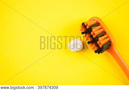 Tooth brush and deciduous milk child teeth on yellow background