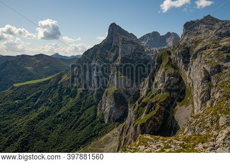 Mountain Peaks With Vegetation And A Sky With Clouds And Lots Of Sun