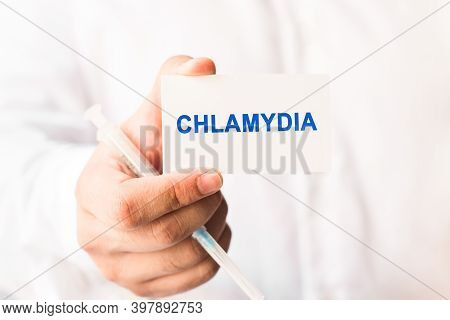 Word Chlamydia On A White Background With A Syringe In Hand. Medicine Concept