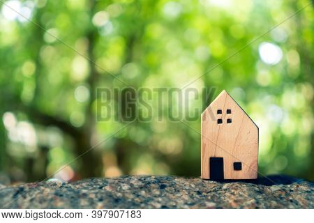 Closed Up Tiny Home Model On Floor Or Wood Board With Sunlight Green Bokeh Background. Deam Life Hav
