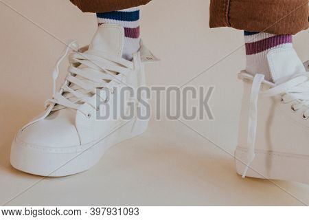 Man in white sneakers with untied laces