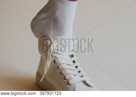 Model putting on white sneaker close up