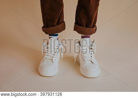 Model wearing white sneakers with untied shoelaces