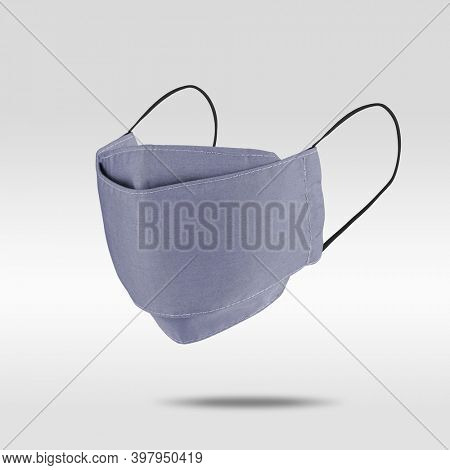 Light purplish-blue fabric face mask on gray background