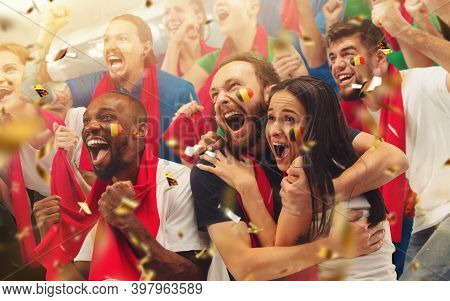 Group Of Happy Fans Cheering For Their Team Victory. Male And Female Models As Fans Of Football Or S