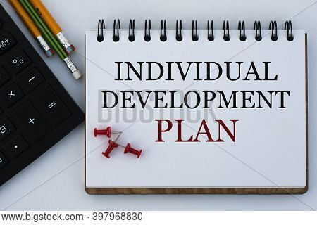 Individual Development Plan - Words On A White Sheet Of Notepad With Buttons, Pencils, Calculator. B
