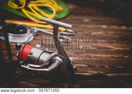 Fishing Tackle On A Wooden Background. Studio Photo With Vignetting.