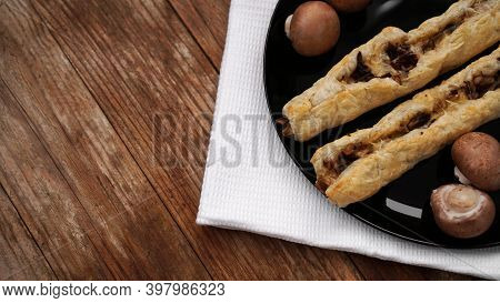 Rollini Delicious Pastries With Mushrooms, Champignons And Cheese On A Black Plate On Wooden Backgro