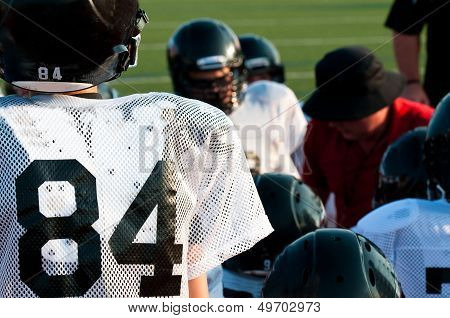 American Football Team In Huddle