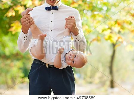 Happy Young Man Holding A Smiling 7-9 Months Old Baby