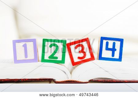 Alphabet block with 1234 on opened book