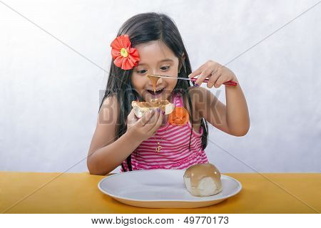 Young girl enjoys buttering bread