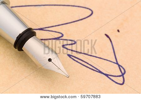 a signature and a fountain pen on yellow paper. symbolic photo for contract testament and graphology