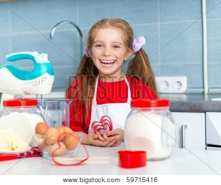 happy little girl holding a cookie cutter in the shape of hearts