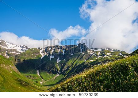 Beautiful Picture Of A Green Mountaintops With A Little Snow