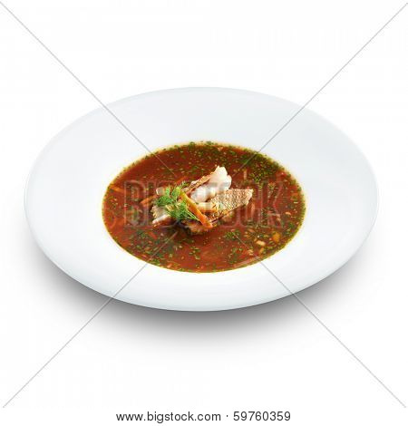 Hot delicious tomato soup with fish and rice served with leek and parsley in a white bowl. Isolated on white. 