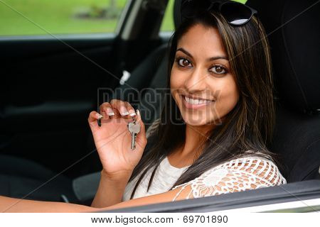 Woman holding up keys to her new car